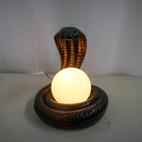 Black plaster table lamp, cobra holding a glass ball
