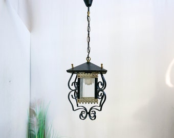 May include: Black wrought iron pendant light fixture with a clear glass shade and a chain hanging from the ceiling.