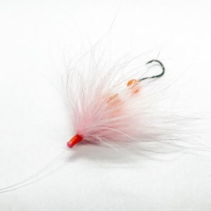 May include: Pink and orange fly fishing lure with a pink feather and a hook.