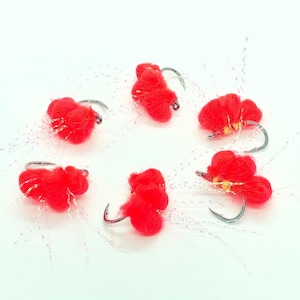 May include: Six red and yellow fly fishing lures with iridescent white fibers.