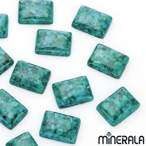 May include: A collection of rectangular turquoise gemstones, displaying a mix of blue, green, and brown tones. The stones are presented on a white background, emphasizing their polished finish. The image showcases several gemstones, highlighting their shape and colour variations.