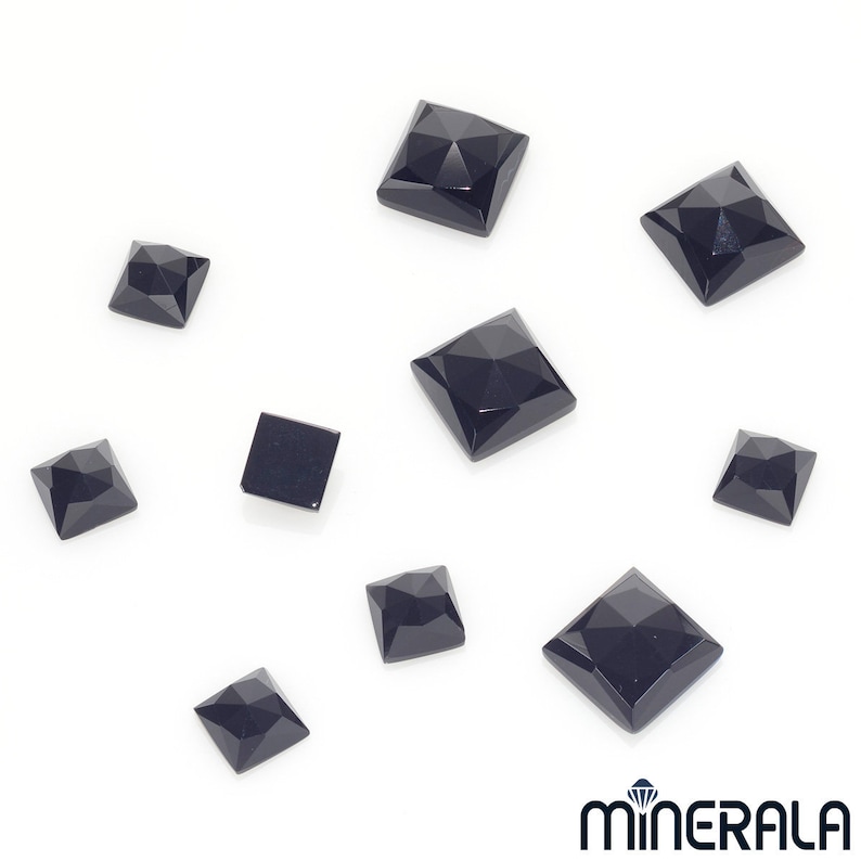 Puede incluir: Un surtido de gemas negras talladas en forma cuadrada y facetadas, sobre un fondo blanco. Las gemas var&iacute;an en tama&ntilde;o y presentan un dise&ntilde;o geom&eacute;trico multifac&eacute;tico. El logotipo "MINERALA" se encuentra en la esquina inferior derecha.