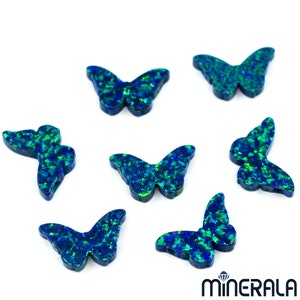 Puede incluir: Siete abalorios de mariposa de &oacute;palo azul y verde. Las mariposas son iridiscentes y tienen un acabado brillante.