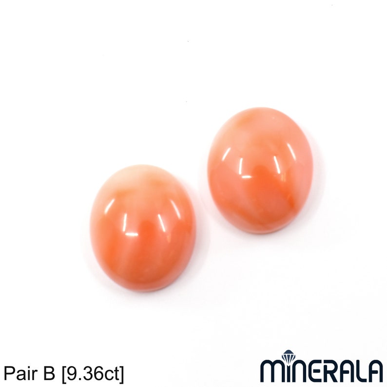 May include: Pair of round, orange coral cabochons, each measuring approximately 1.5 cm in diameter. The coral is a light orange color with a smooth, polished surface. The cabochons are set against a white background. Pair B [9.36ct]