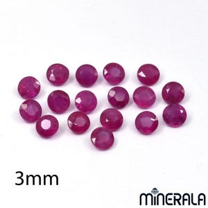 Op de afbeelding: Een verzameling van zestien ronde, gefacetteerde, dieproze robijnen, elk met een diameter van 3 mm. De edelstenen zijn in een losse groep gerangschikt tegen een effen witte achtergrond. De tekst 3mm en de merknaam MINERALA zijn zichtbaar.