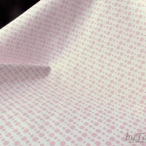 Può includere: Tessuto bianco con un motivo a spirale rosa. Il tessuto è piegato a metà e il motivo è visibile su entrambi i lati.