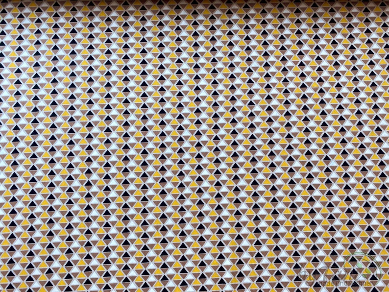 May include: A seamless fabric pattern with a repeating geometric design of small triangles in shades of brown, yellow, white, and black.