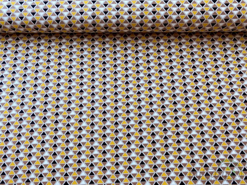May include: A fabric with a repeating pattern of small triangles in brown, yellow, white and black.