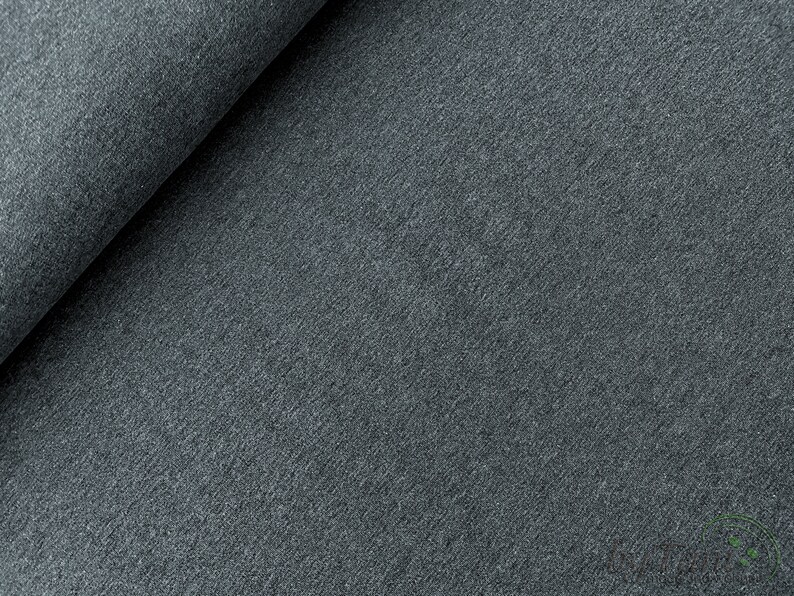 May include: Close-up of a dark gray textured fabric. The fabric has a soft, fuzzy feel and a slightly mottled appearance.