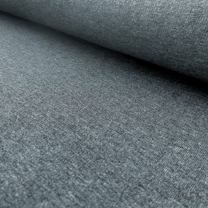 May include: Close-up of a gray, textured fabric. The fabric has a slightly rough, uneven surface.