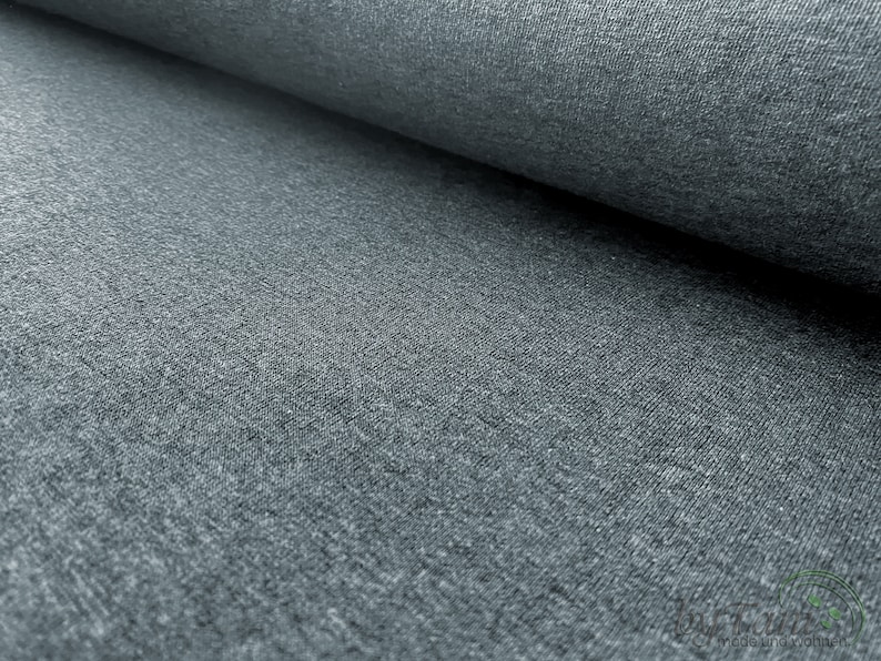 May include: Close-up of a gray, textured fabric. The fabric has a slightly rough, uneven surface.