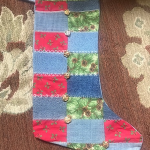 May include: A patchwork Christmas stocking made from denim and red and green fabric with gold jingle bells.