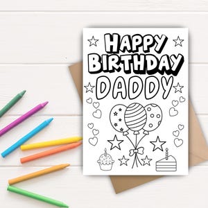 Könnte beinhalten: Eine Schwarz-Weiß-Ausmalkarte mit dem Text "HAPPY BIRTHDAY DADDY" und Illustrationen von Luftballons, Sternen, einem Cupcake und einem Kuchen. Mehrere bunte Buntstifte liegen verstreut um die Karte auf einer weißen Holzoberfläche.