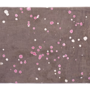 May include: A brown fabric with pink and white splatter paint. The fabric has a subtle texture.