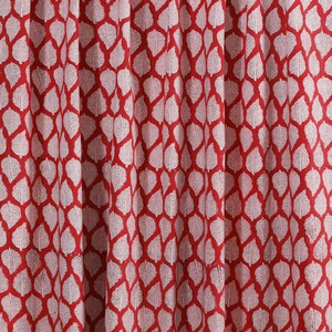 May include: Red fabric with a white leaf pattern. The leaves are arranged in a repeating pattern.