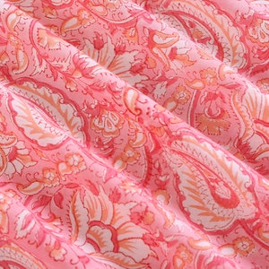 Puede incluir: Tela rosa con un patr&oacute;n paisley blanco. La tela es suave y fluida, con un delicado dise&ntilde;o floral.