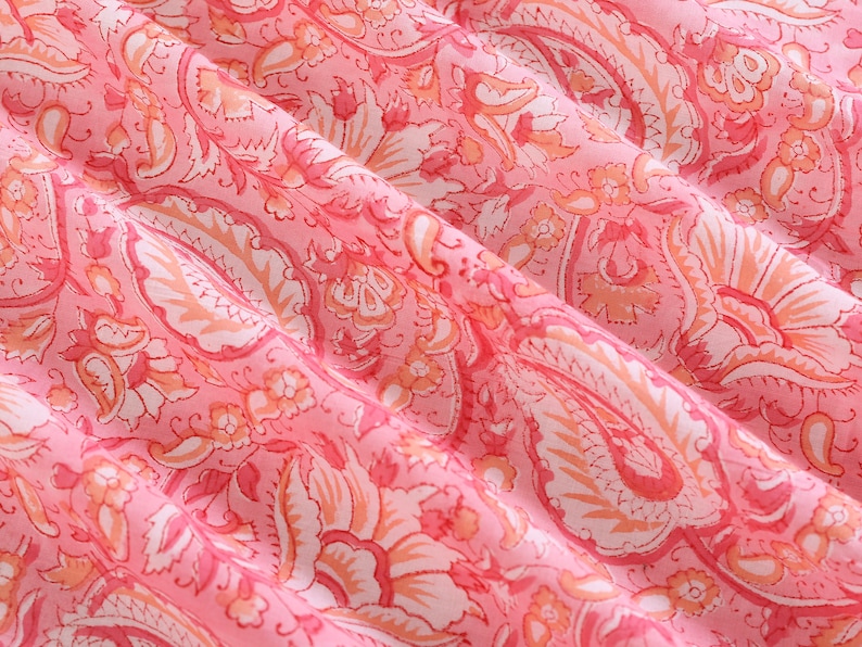 Puede incluir: Tela rosa con un patr&oacute;n paisley blanco. La tela es suave y fluida, con un delicado dise&ntilde;o floral.