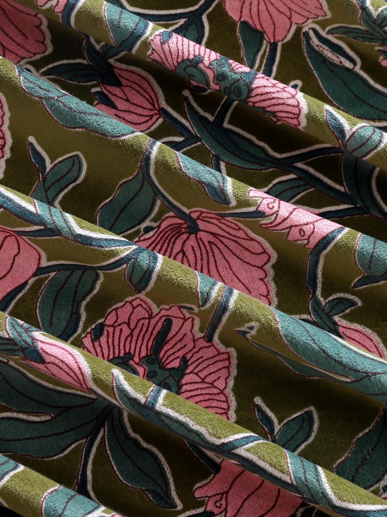 Pode incluir: Um tecido com um padr&atilde;o floral repetitivo com grandes flores cor-de-rosa e folhas verde-escuras sobre um fundo verde-azeitona. O design inclui contornos brancos finos &agrave; volta das p&eacute;talas e da folhagem, criando um aspeto texturado e em camadas.