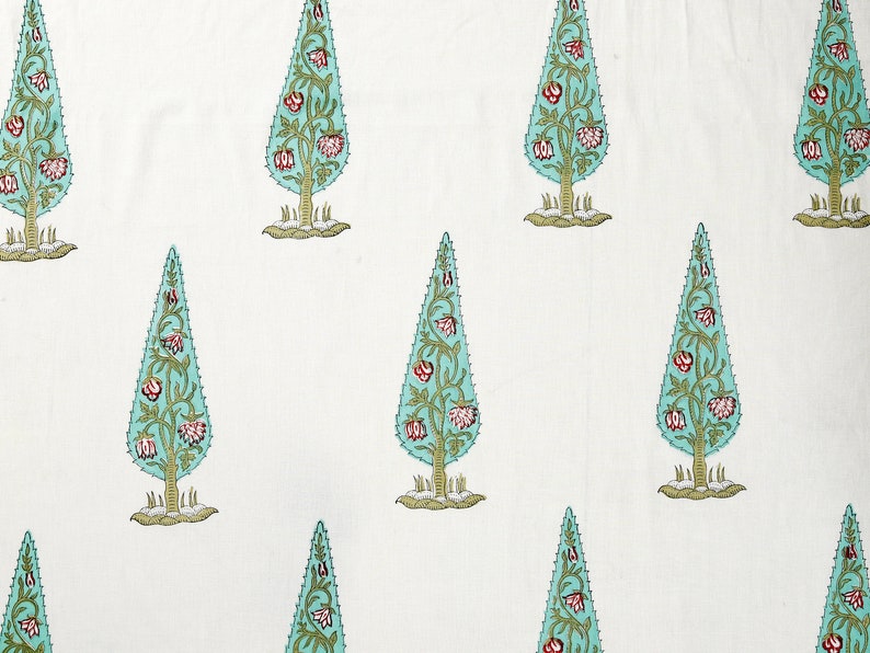 May include: White fabric with a repeating pattern of teal blue stylized trees with pink flowers. The trees have a jagged outline and are set against a white background.