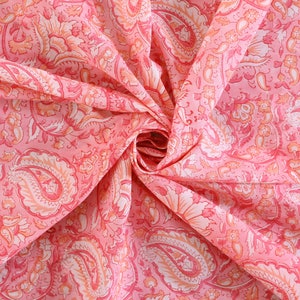Puede incluir: Tela rosa con un patr&oacute;n de paisley. La tela est&aacute; doblada y retorcida, mostrando los intrincados detalles del dise&ntilde;o.