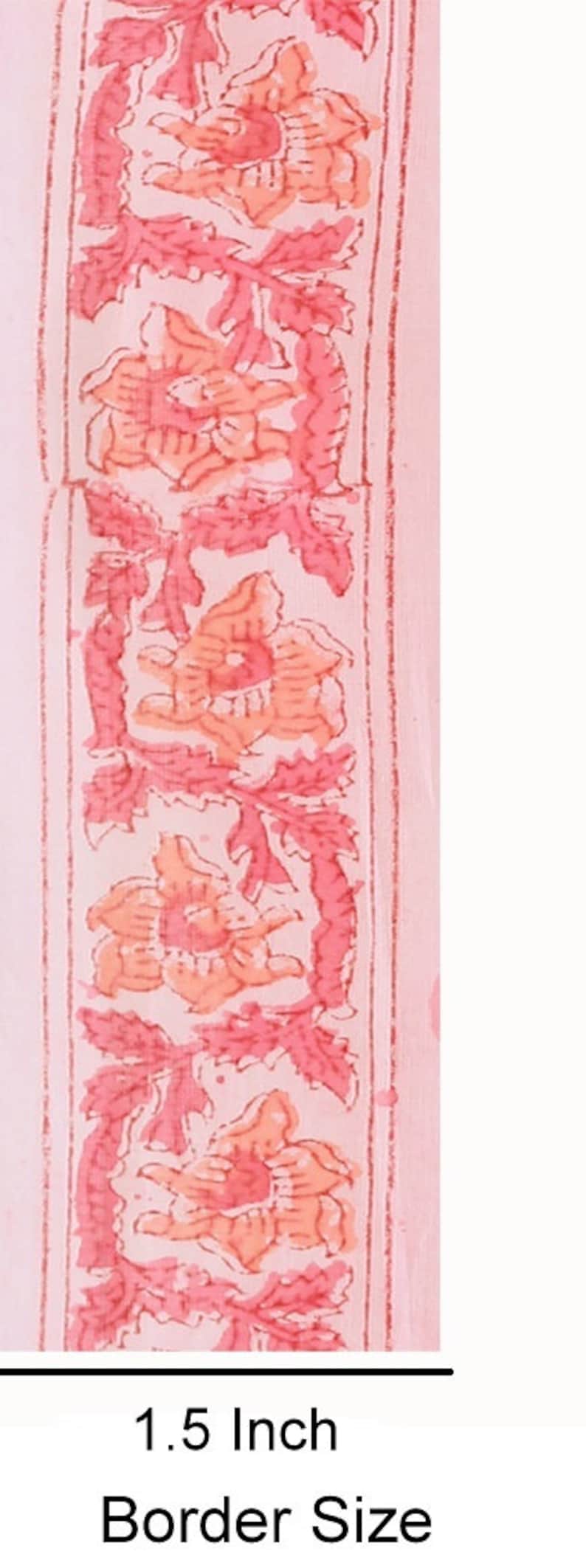 Puede incluir: Tela rosa con un dise&ntilde;o de borde floral. El borde tiene 1,5 pulgadas de ancho y presenta flores rosas y naranjas con hojas verdes.
