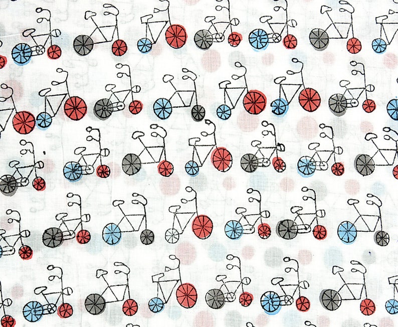 May include: A white fabric with a repeating pattern of black tandem bicycles with red and blue wheels. The background is a light gray with small pink and white dots.