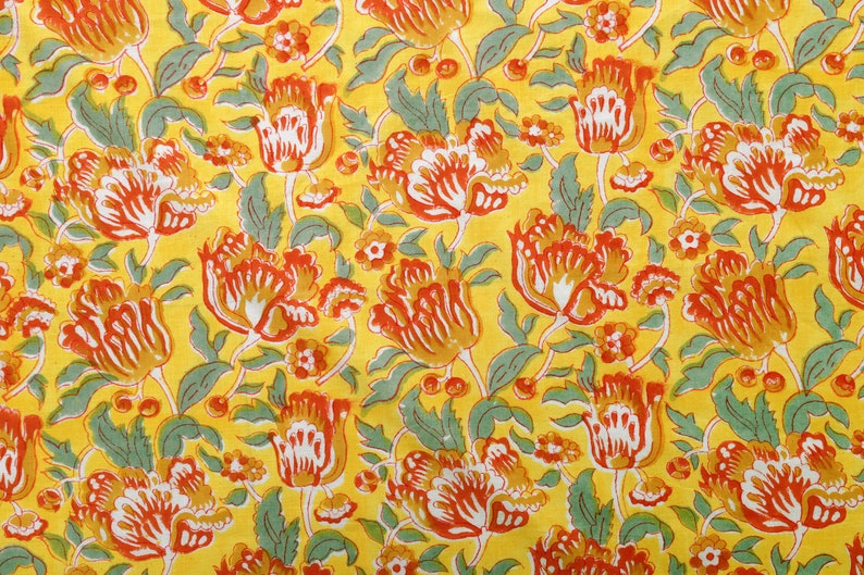 Puede incluir: Una tela amarilla con un patr&oacute;n repetitivo de dise&ntilde;os florales rojos, naranjas y verdes.