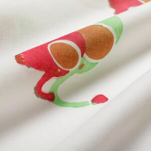 Puede incluir: Tela blanca con un patr&oacute;n repetido de formas abstractas rojas, naranjas y verdes. La tela tiene una textura suave y fluida.