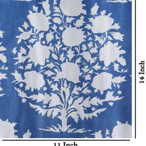 May include: A blue and white floral fabric with a repeating pattern of white flowers and leaves on a blue background. The fabric measures 11 inches by 14 inches.