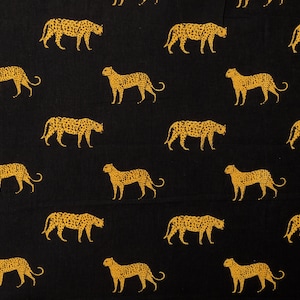 Può includere: Tessuto nero con un motivo ripetuto di silhouette di leopardi dorati. I leopardi sono rivolti a destra e sono stampati in uno stile realistico.