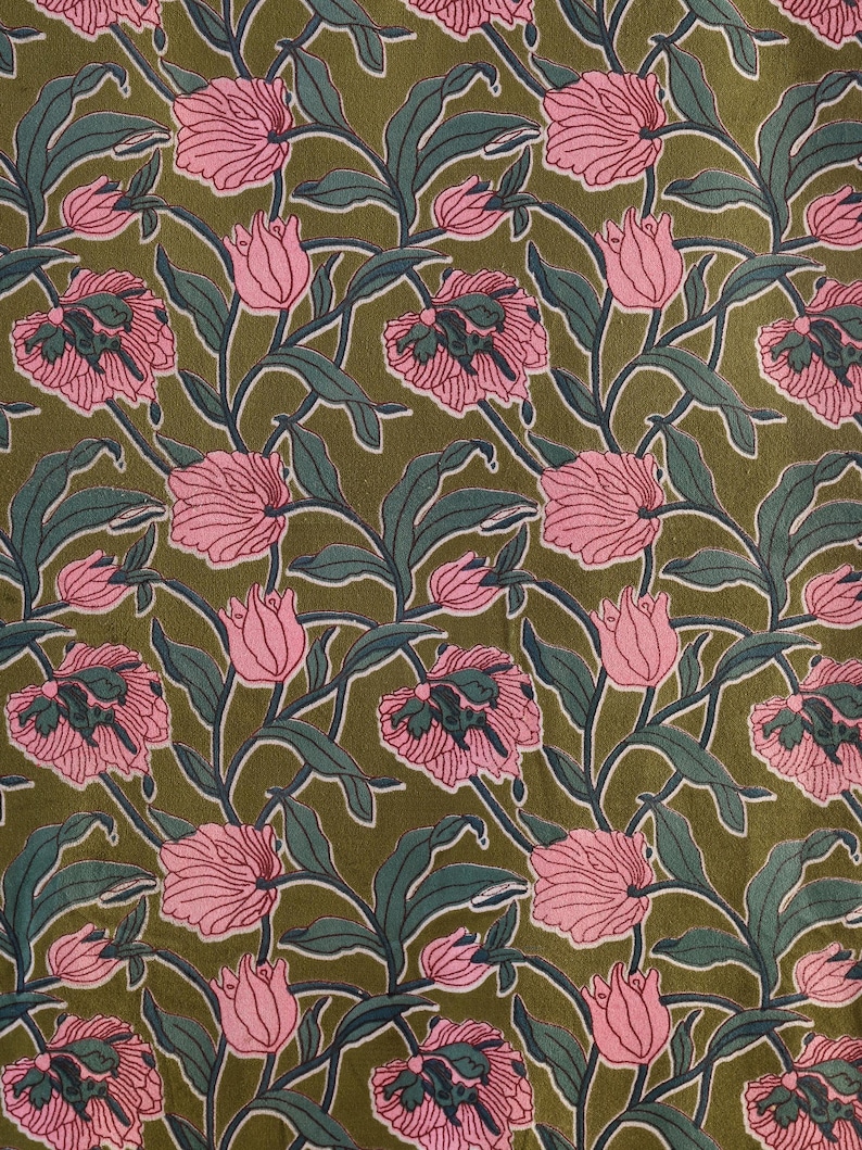 Pode incluir: Um tecido com um padr&atilde;o floral repetitivo de tulipas cor-de-rosa com folhas e caules verde-escuros sobre um fundo verde-azeitona. O design consiste em flores e folhagens estilizadas dispostas num motivo bot&acirc;nico fluido e cont&iacute;nuo.