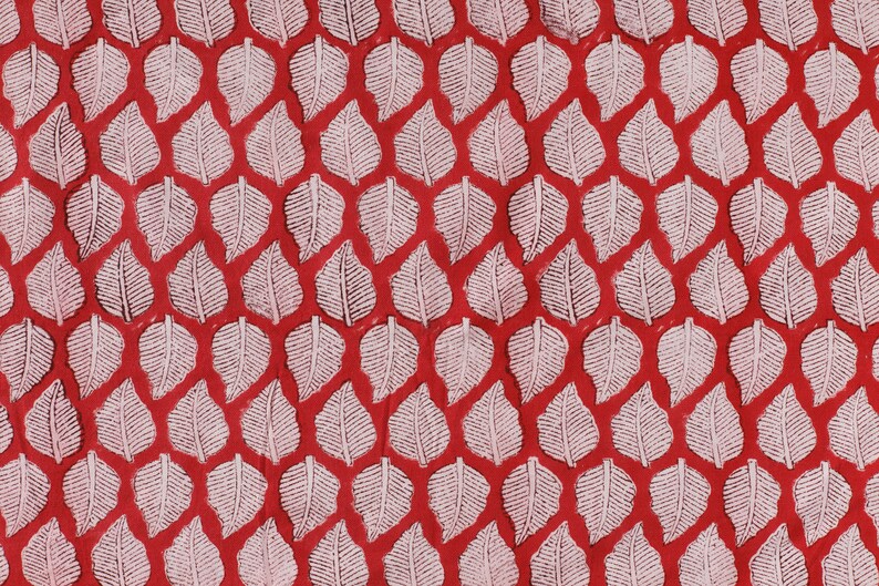 May include: A red background with a repeating pattern of white leaf shapes.