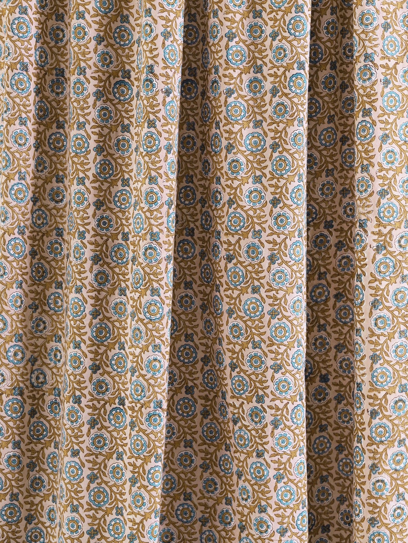 May include: A pink fabric with a repeating pattern of blue and brown floral designs.