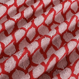 May include: Red fabric with a white leaf pattern. The leaves are a repeating pattern and are slightly raised.