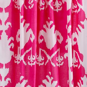 Op de afbeelding: Roze en witte stof met een herhalend patroon van gestileerde bloemmotieven. De stof heeft een zachte, vloeiende textuur.
