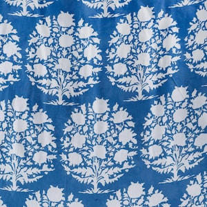 May include: A blue fabric with a white floral pattern. The pattern is a repeating design of stylised flowers and leaves.