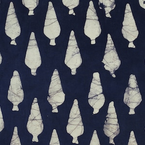 May include: A navy blue fabric with a white pattern of repeated teardrop shapes. The fabric has a batik style design.