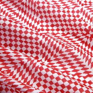 May include: Red and white checkered fabric with a subtle pattern. The fabric is folded and has a soft, textured surface.