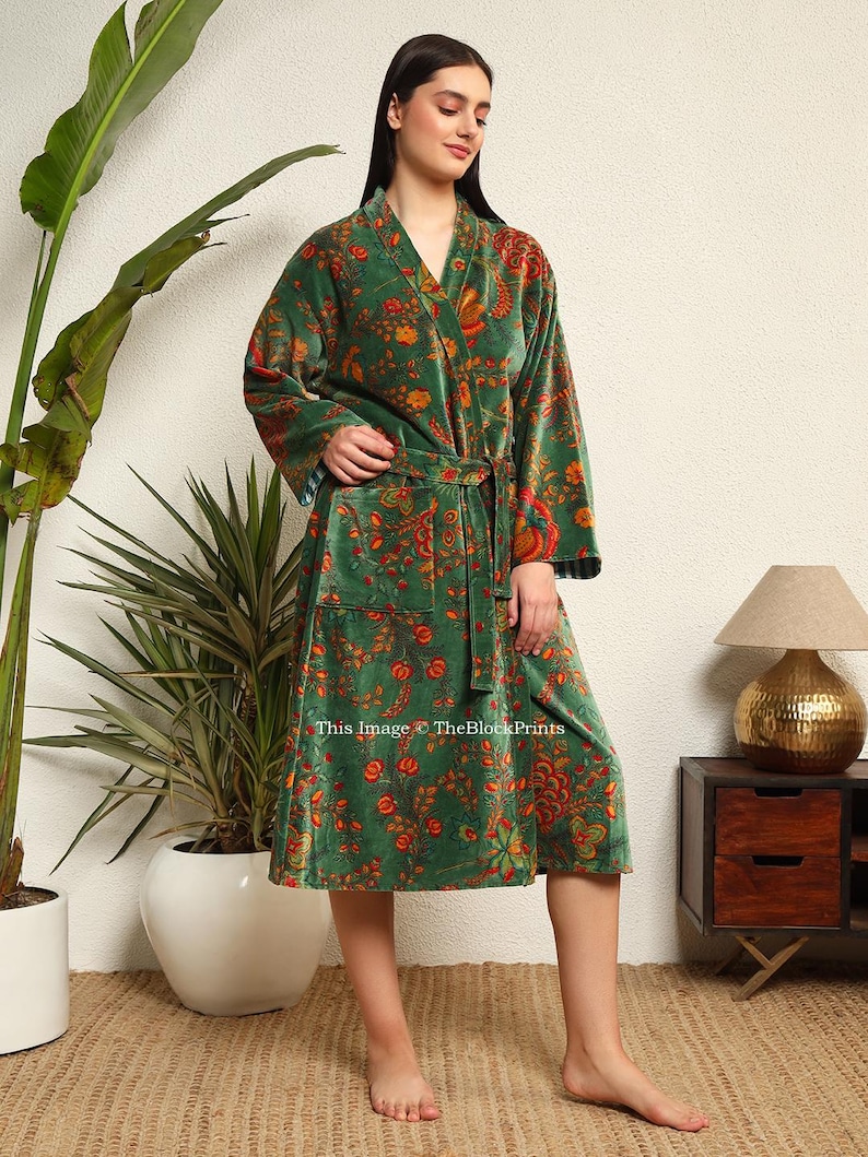 May include: A green velvet robe with a floral print and a tie belt. The robe has a long sleeve and a knee-length hem. This image &copy; TheBlockPrints
