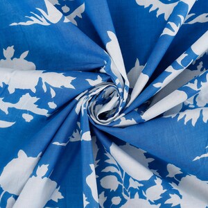 May include: Blue fabric with a white floral pattern. The fabric is folded and the pattern is visible on both sides.