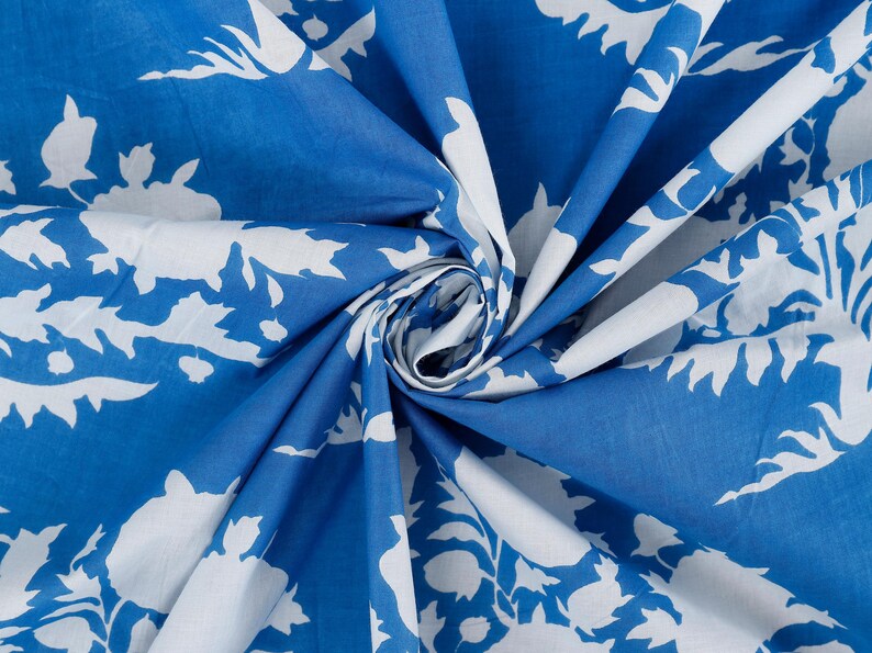 May include: Blue fabric with a white floral pattern. The fabric is folded and the pattern is visible on both sides.