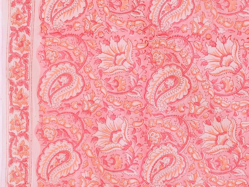 Puede incluir: Tela rosa con un patr&oacute;n de paisley. La tela tiene un fondo blanco con dise&ntilde;os de paisley rosa y naranja.