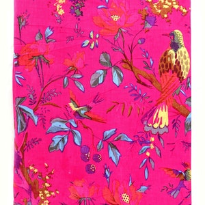 May include: Pink fabric with a floral and bird print. The fabric features a repeating pattern of pink, red, blue, yellow, and brown flowers, leaves, and birds.
