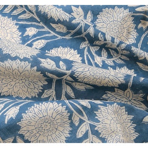 Puede incluir: Una tela azul con un patr&oacute;n floral blanco. La tela est&aacute; doblada y tiene una textura suave.