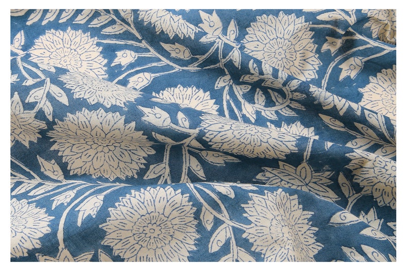Puede incluir: Una tela azul con un patr&oacute;n floral blanco. La tela est&aacute; doblada y tiene una textura suave.