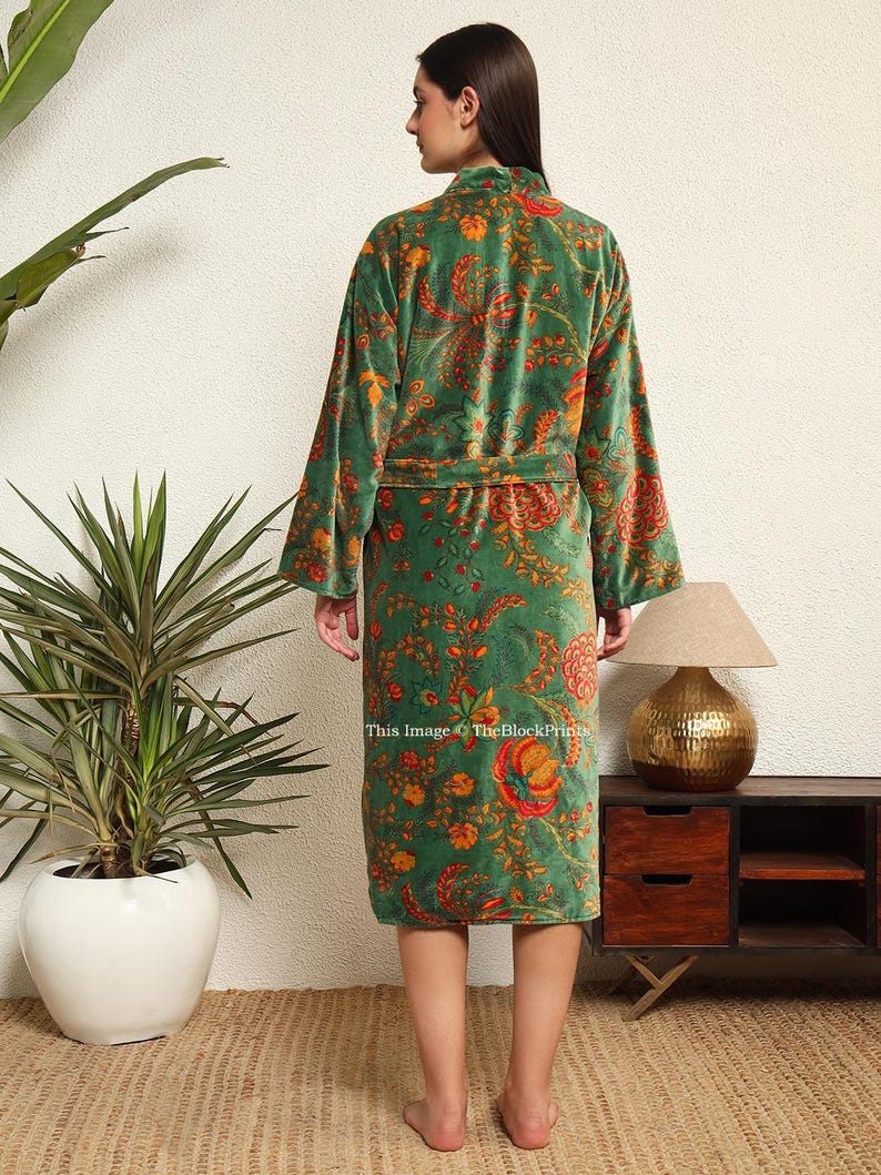 May include: A green velvet robe with a floral print. The robe has a tie belt and long sleeves.