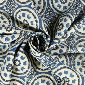K&ouml;nnte beinhalten: Nahaufnahme eines blauen und wei&szlig;en Stoffes mit einem sich wiederholenden Muster aus kreisf&ouml;rmigen Designs. Der Stoff ist gefaltet und drapiert, wodurch die komplizierten Details des Musters sichtbar werden.