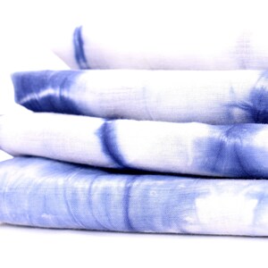 Peut inclure: Un empilement de quatre carr&eacute;s de tissu bleu et blanc en tie-dye.