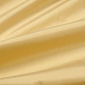 Puede incluir: Primer plano de una tela lisa de color amarillo p&aacute;lido con pliegues y arrugas suaves.