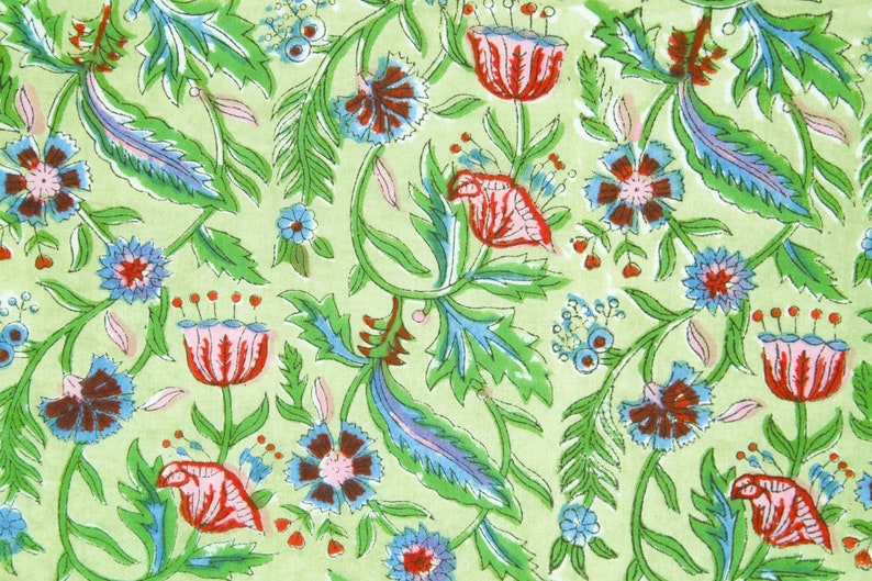 Puede incluir: Patr&oacute;n floral repetido sobre un fondo verde claro. El dise&ntilde;o presenta flores rojas, azules y marrones con hojas y vides verdes. El patr&oacute;n es detallado e intrincado, creando un dise&ntilde;o textil visualmente atractivo.